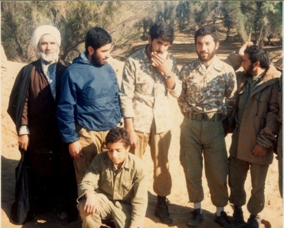 فرد نشسته در سمت چپ تصویر شهید رمضان علی هادیان